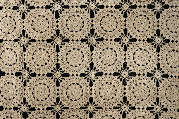 old handmade lace pattern background on a black background.
