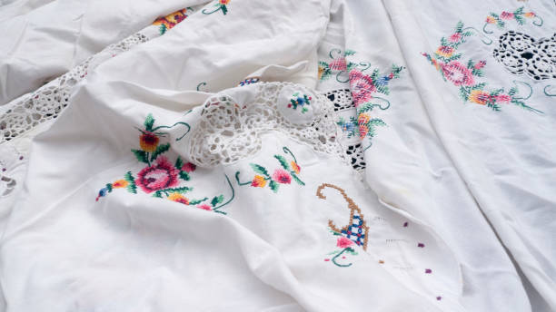 colored embroidery in the shape of a flower on a white tablecloth